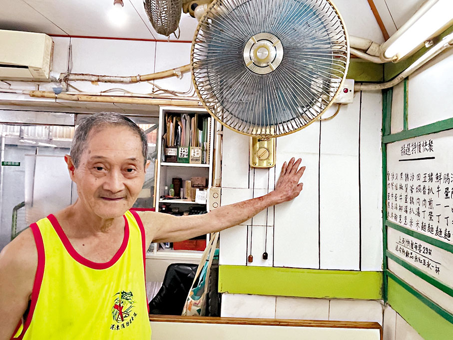 ◆店主周先生指着店內被水浸過的痕跡，高度約1.6米。 香港文匯報記者吳健怡  攝