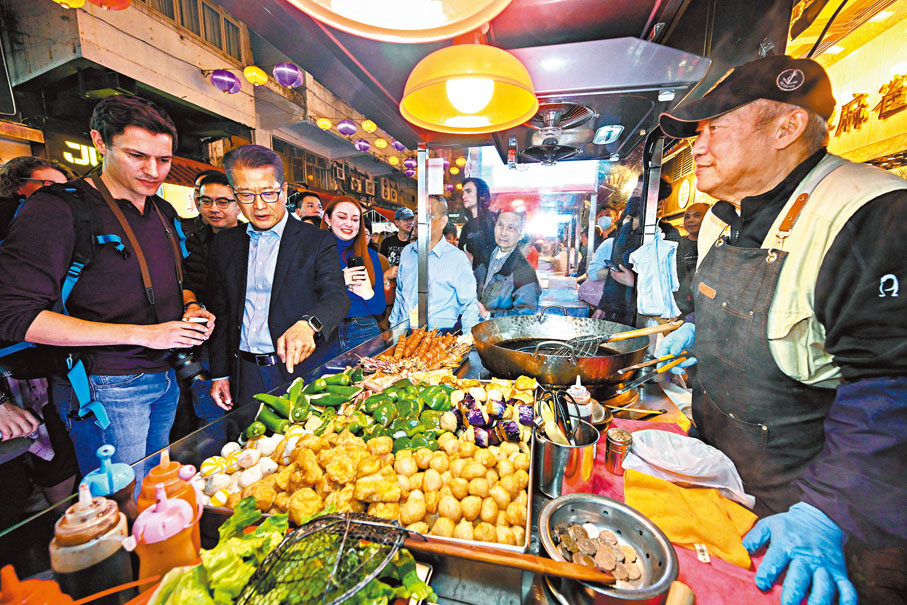 ◆陳茂波日前在廟街跟旅客一起分享攤檔美食，為他們介紹廟街歷史以及本地的小食文化，並送上新年祝福。網誌圖片