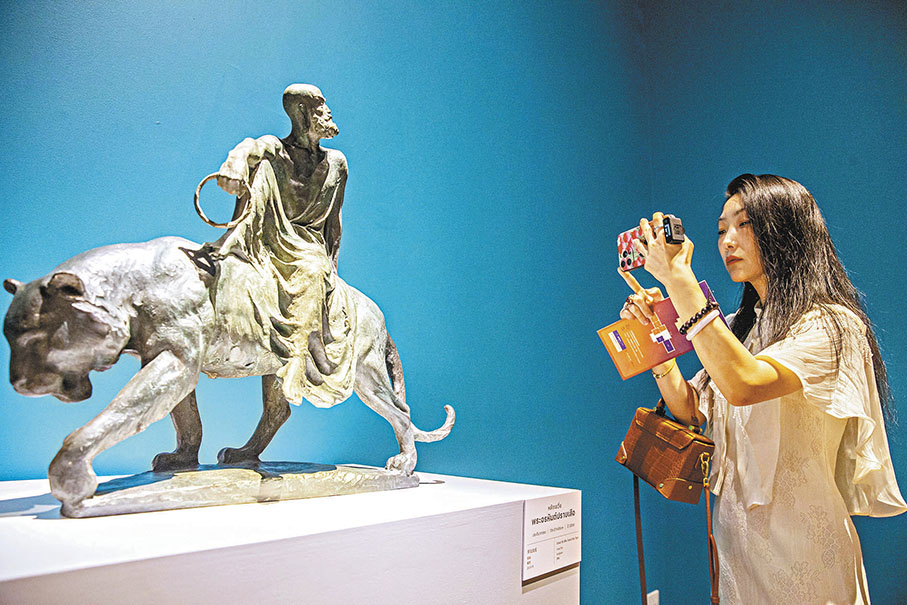◆參觀者為《羅漢伏虎》雕塑作品拍照。