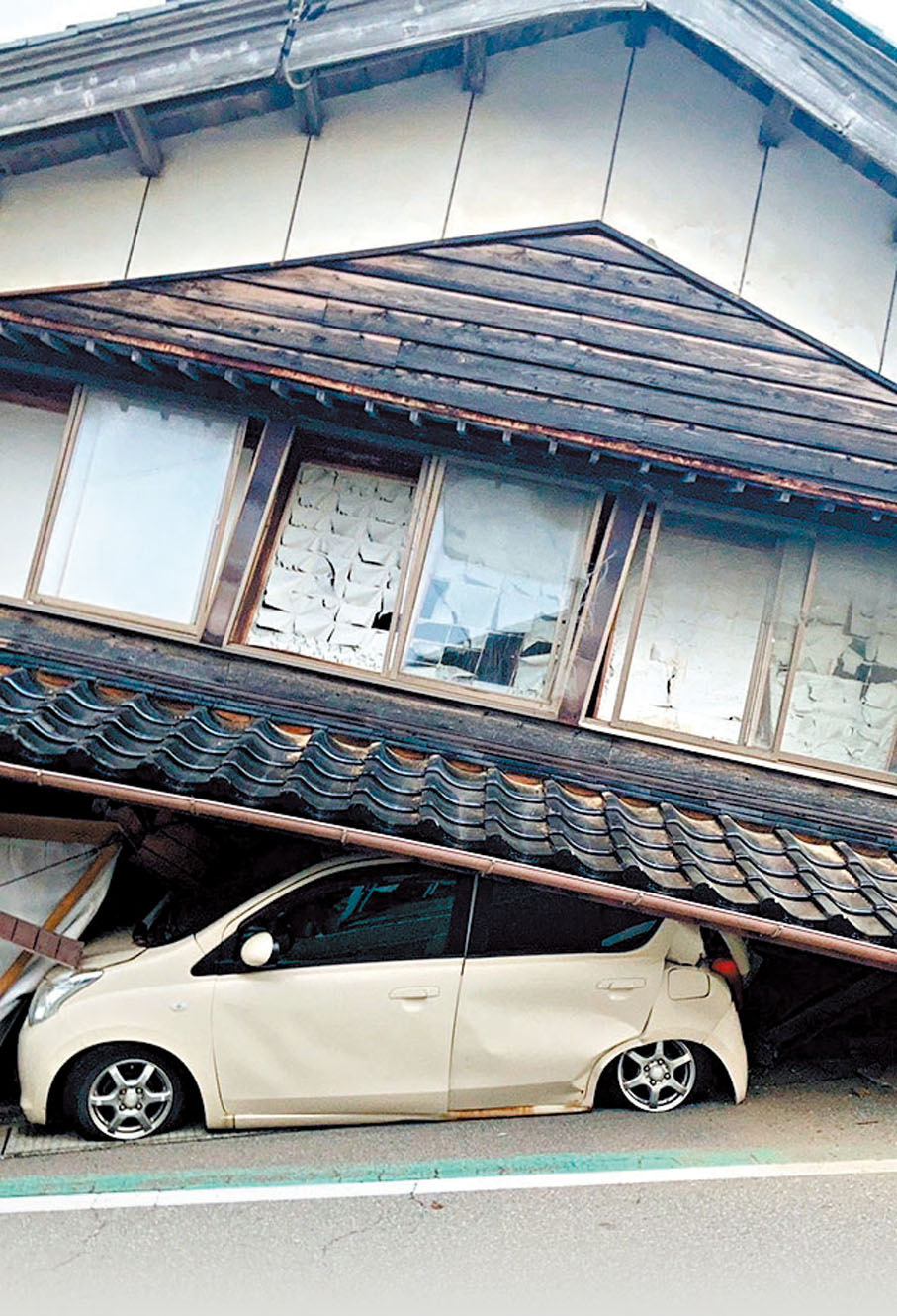 ◆有汽車被倒塌房屋壓住。 路透社
