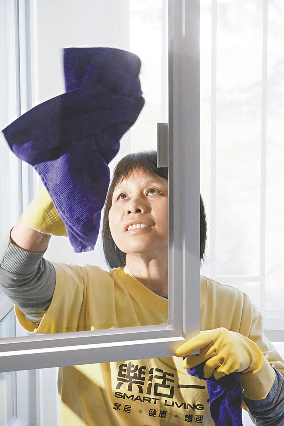 ◆家居清潔經驗豐富的陳杏珍說，抹窗需注重安全，頭和身須留在室內。 香港文匯報記者涂穴 攝