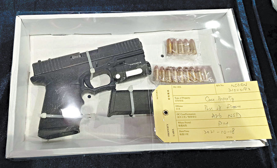 ◆當日警方在記者會上展示在被告八鄉村屋內搜出的P80自動手槍、子彈及子彈匣證物。 資料圖片