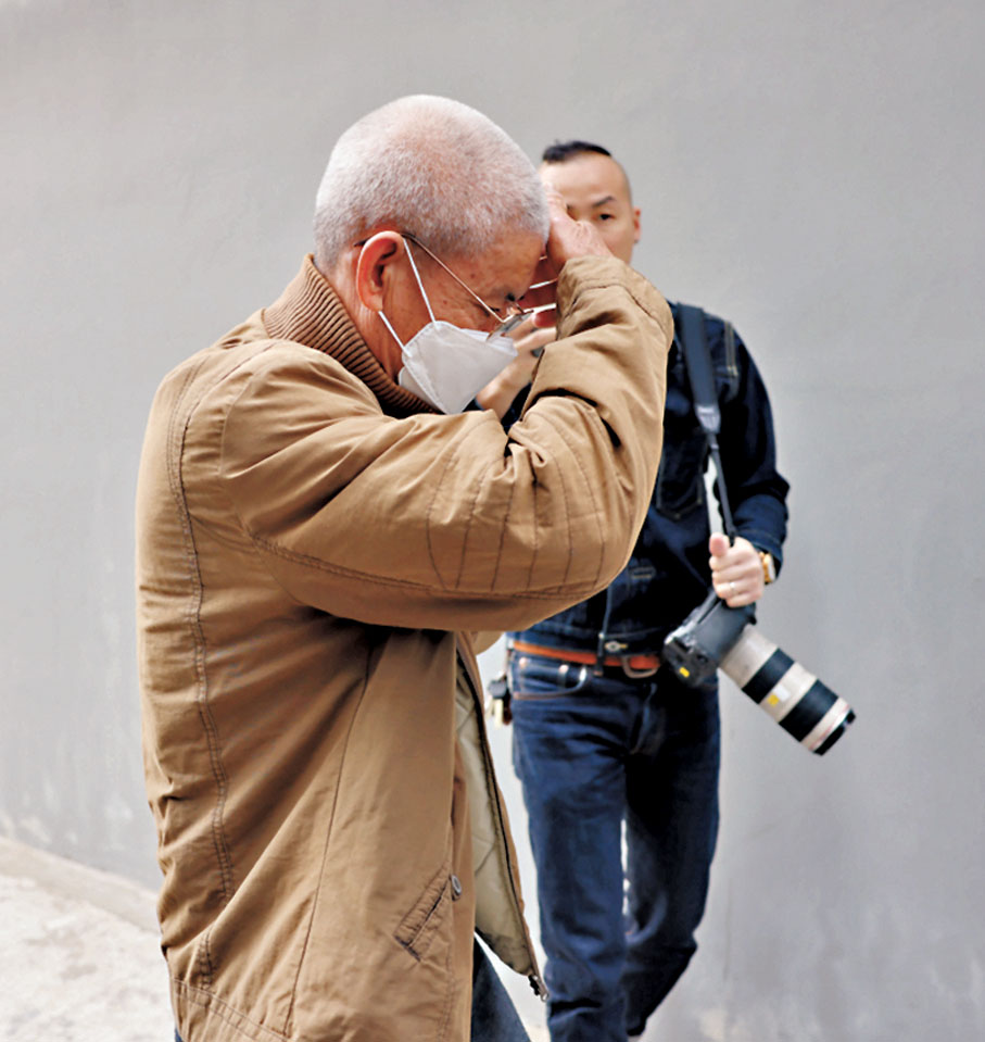 ◆鄭父昨日中午離開青山警署時用手掩面躲開記者拍攝。香港文匯報記者劉友光 攝