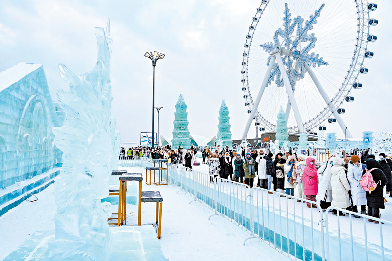 ◆1月4日，在哈爾濱冰雪大世界園區內，遊客觀賞冰雕作品。 新華社