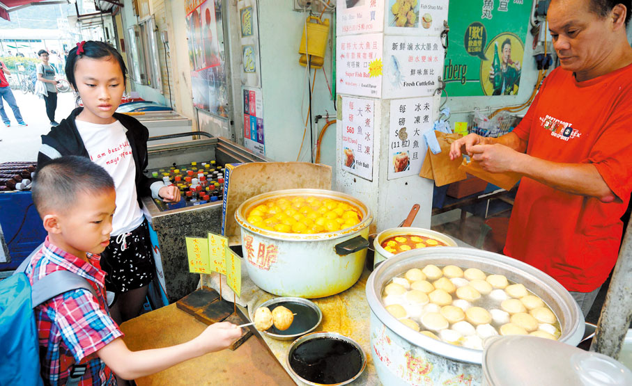 ◆ 圖為兒童在香港街頭一家特色小吃店購買魚蛋。 資料圖片