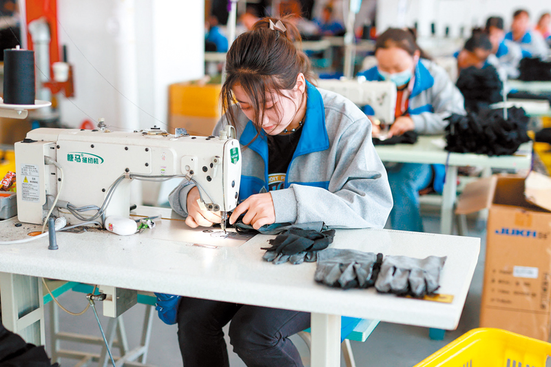 ◆2023年，中國全年規模以上工業增加值同比增長4.6%，製造業總體規模連續14年保持全球第一。圖為新疆伊犁卓萬服飾製造有限公司內，工人在進行手套的縫作工作。 中通社