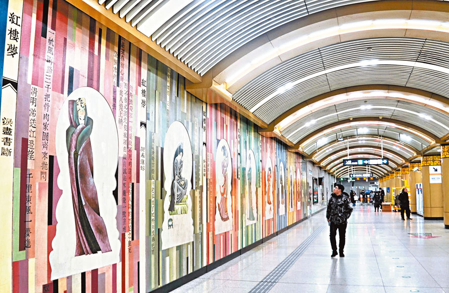 ◆北京打造「地下藝術空間」。圖為乘客在磁器口地鐵站內觀看「紅樓夢」壁畫。 新華社