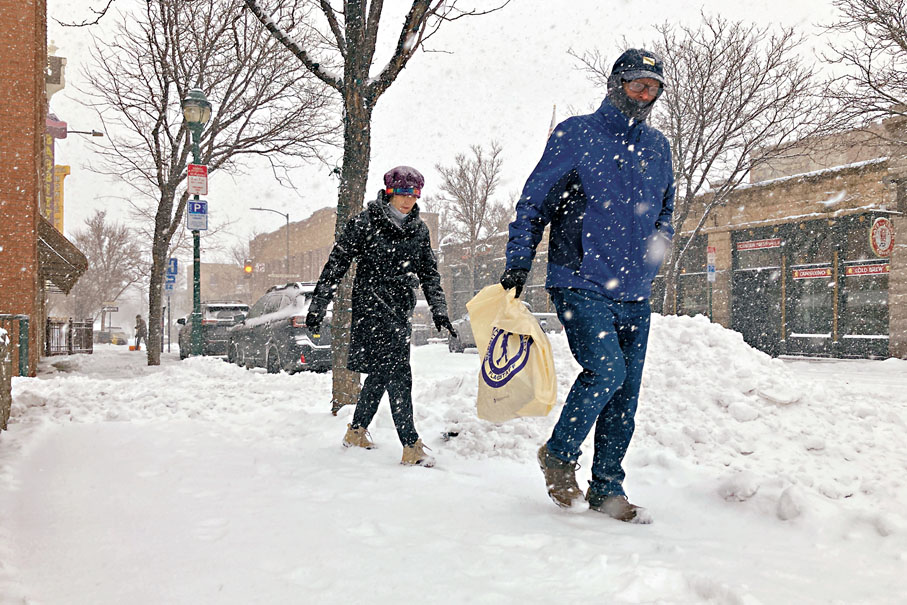 ◆亞利桑那州弗拉格斯塔夫市遇雪暴，人們冒雪行走。美聯社