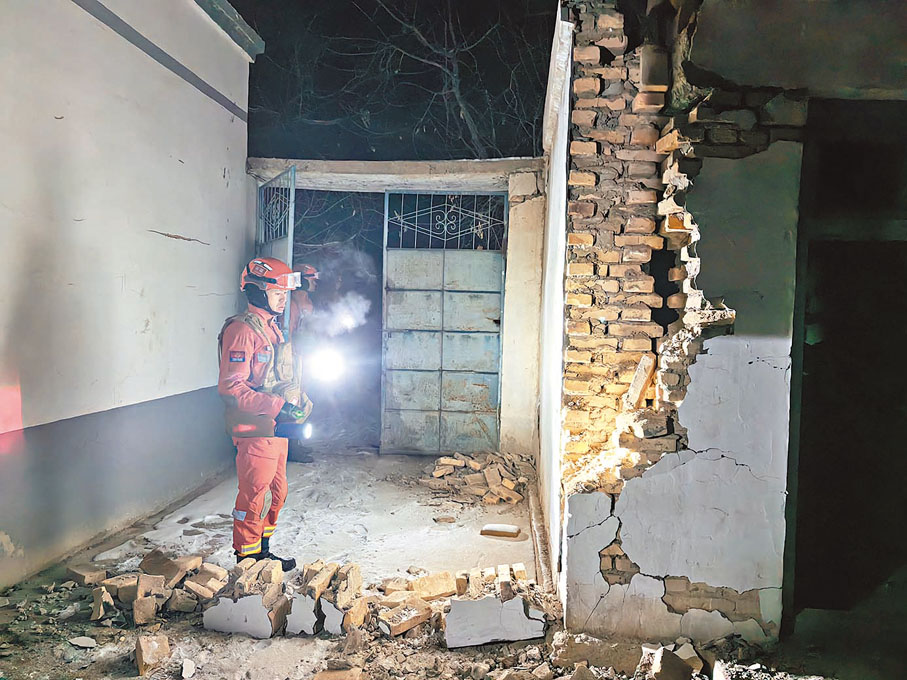 ◆23日凌晨，救援人員在烏什縣亞曼蘇柯爾克孜族鄉檢查房屋受損情況。 中新社