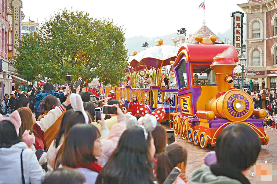 ◆香港迪士尼樂園熱鬧的花車巡遊，遊客紛紛拿起手機記錄這美好的瞬間。大公文匯全媒體記者麥鈞傑  攝