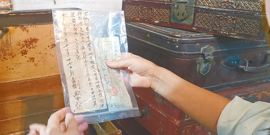 ◆胡海平展示來自粵東的箱子中的資料。