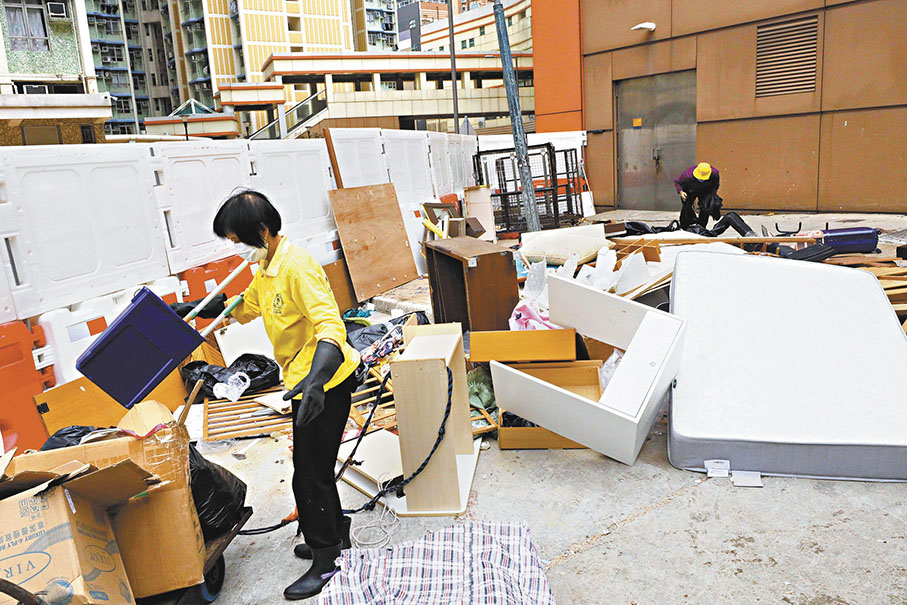 ◆物管公司須支付額外的大型垃圾處理費用，按重量收費。圖為清潔工人在清理大型家居垃圾。 香港文匯報記者北山彥  攝