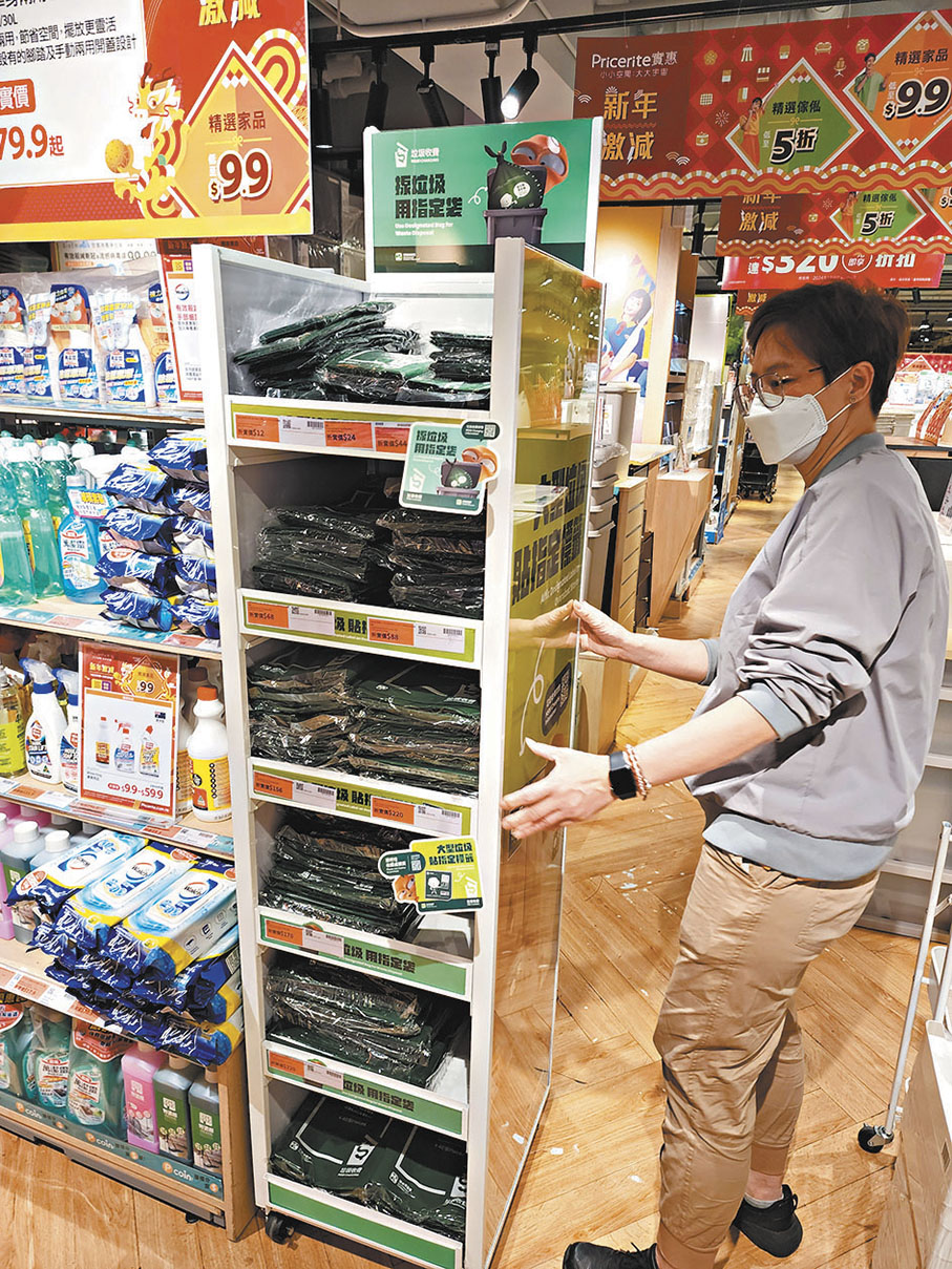 ◆垃圾收費指定袋已開售，圖為家品店職員展示收費垃圾袋。 香港文匯報記者曾興偉  攝