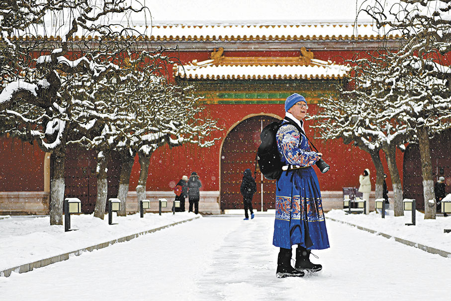 ◆身穿傳統服飾的遊客在太廟前琉璃門前拍攝雪景。