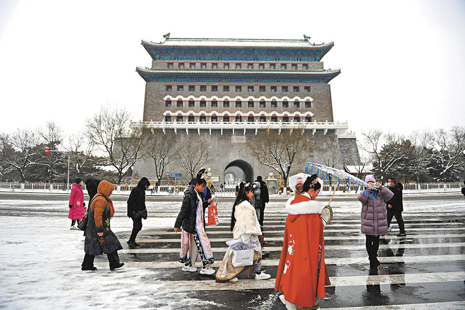 ◆遊客行走在雪後的正陽門箭樓前。
