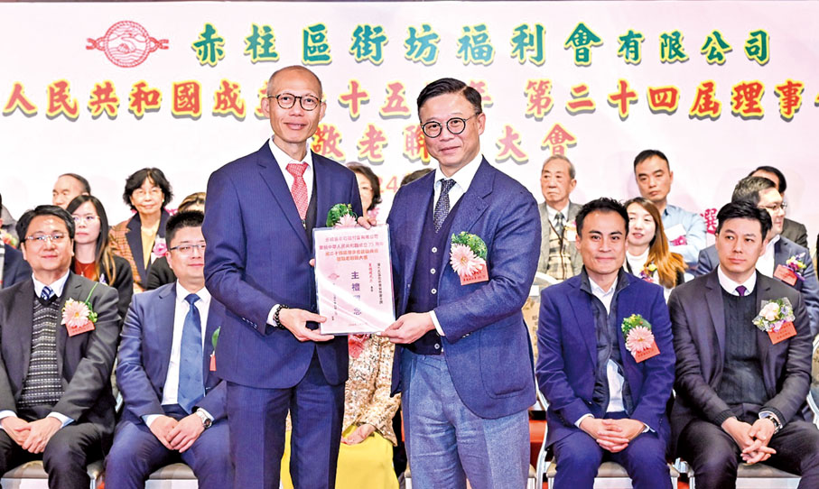 ◆ 張國鈞頒發證書予港九各區街坊會協會主席夏德建。