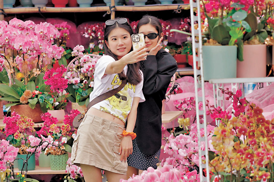 ◆壽小姐（左）及楊小姐在花叢中拍照，人花爭艷。香港文匯報記者北山彥 攝