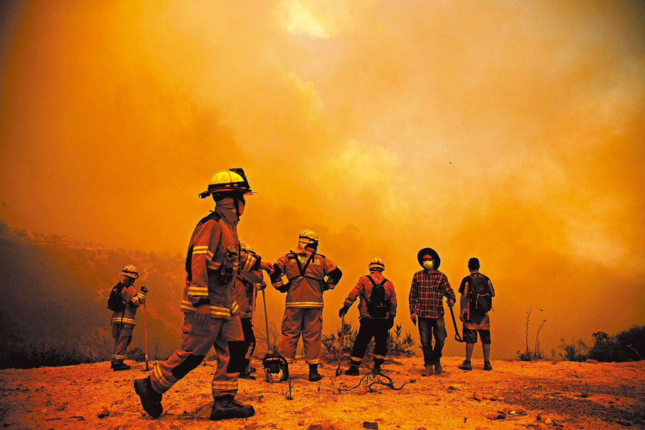 ◆智利消防員在瓦爾帕萊索山區進行搜救。 法新社
