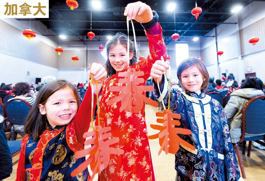 ◆身穿中國傳統服飾的兒童在廟會上展示剪紙作品。 新華社