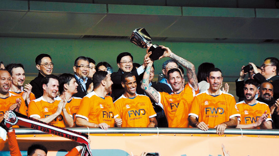 ◆世界明星隊球員馬達拉斯，從特首李家超手中接過賀歲盃獎盃。