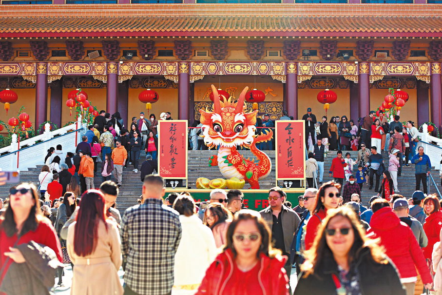 ◆當地時間2月10日，美國佛光山西來寺大雄寶殿前搭建的「歡喜龍」主燈伴隨遊客迎新春。 中新社