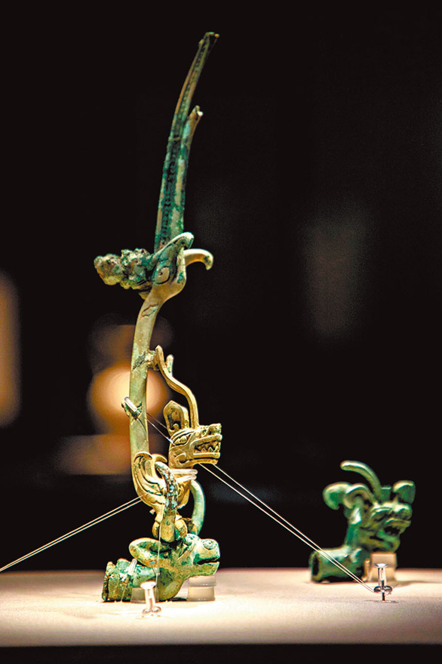◆廣漢市三星堆遺址出土的青銅祭壇零件（左）和龍形銅飾（右）。主辦方供圖