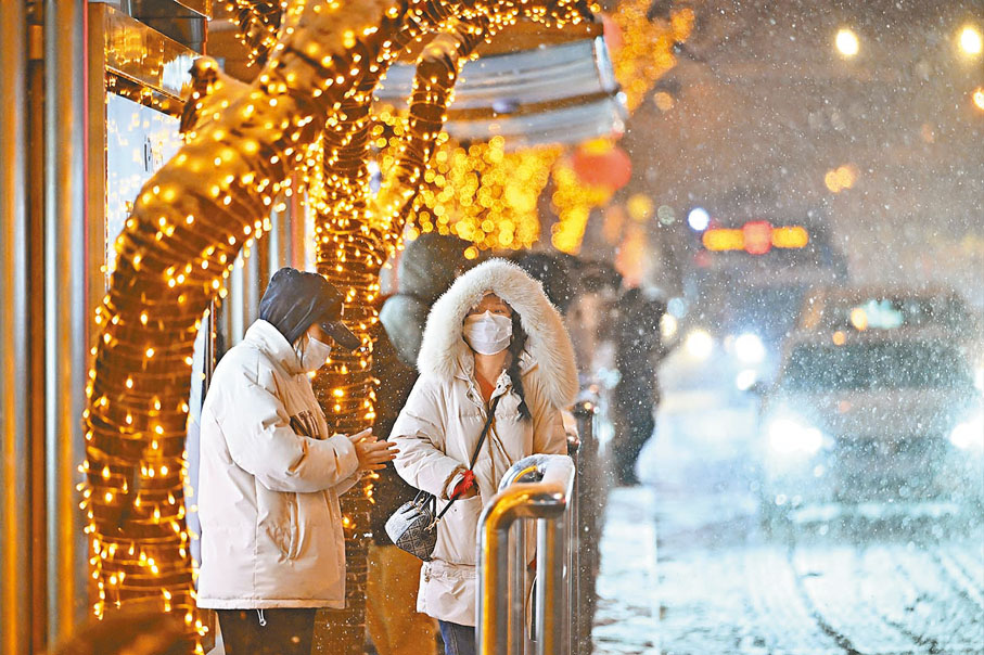 ◆2月20日，北京城區迎來甲辰龍年首場降雪。圖為市民雪中等待公交車。  中新社