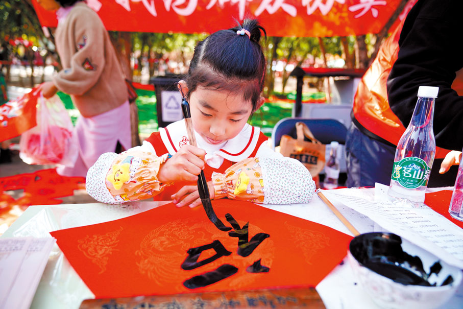 ◆【昆明】學書法的小朋友在翠湖公園為現場市民寫福。