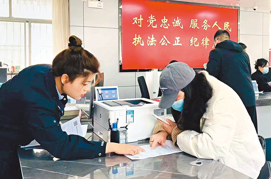 ◆3月6日，西安市民可就近選擇辦理往來港澳通行證和赴港澳「個人旅遊簽註」。圖為一市民在出入境業務受理點辦理證件。香港文匯報西安傳真