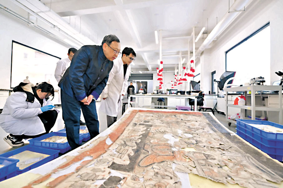◆在雲岡研究院壁畫文物修復室，杭侃（前）和同事交流壁畫修復方案。 網上圖片