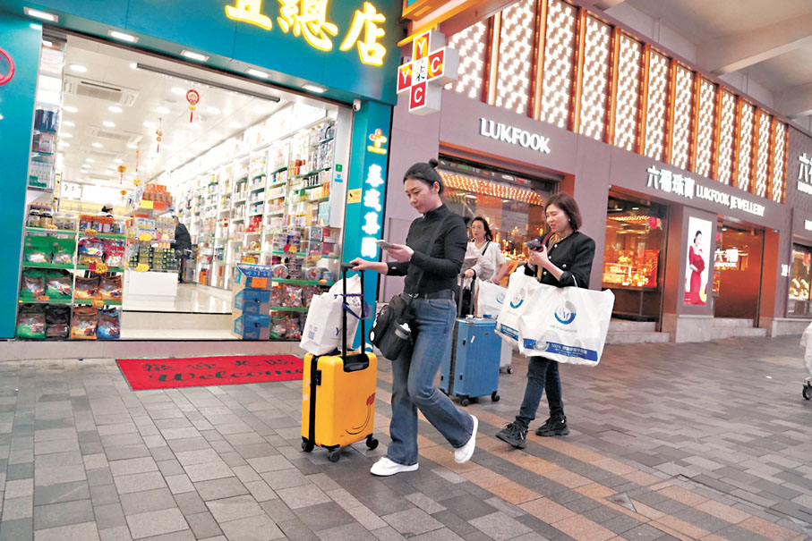 ◆ 不少遊客手持大包小袋，滿載而歸。香港文匯報記者曾興偉 攝
