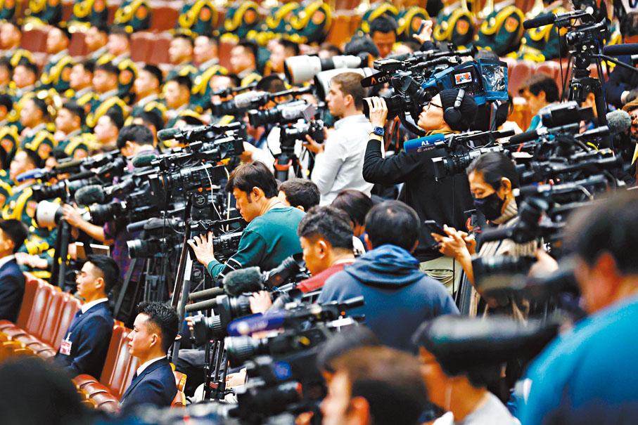◆3月5日，十四屆全國人大二次會議在北京人民大會堂開幕。圖為中外記者聚焦會議。中新社