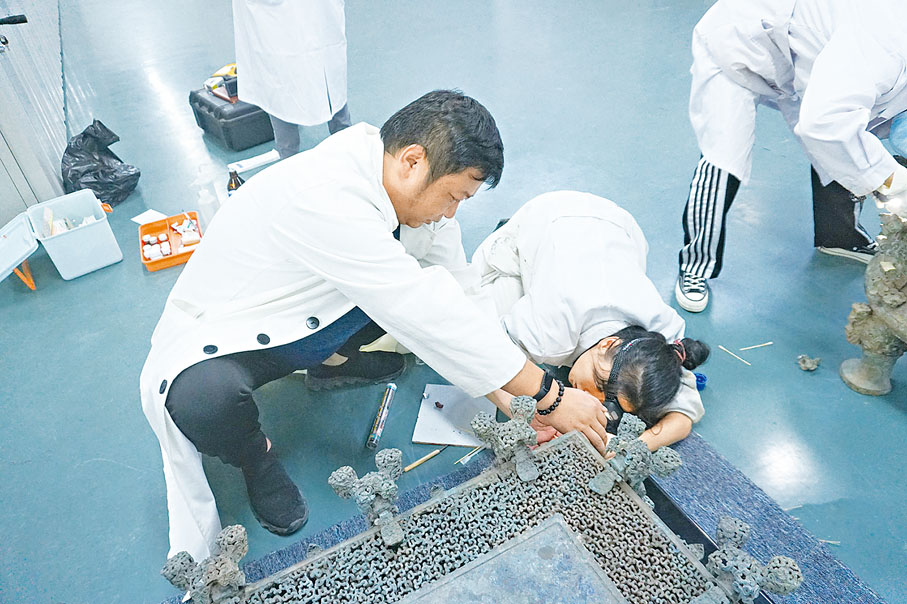 ◆河南博物院工作人員在修復雲紋銅禁。 