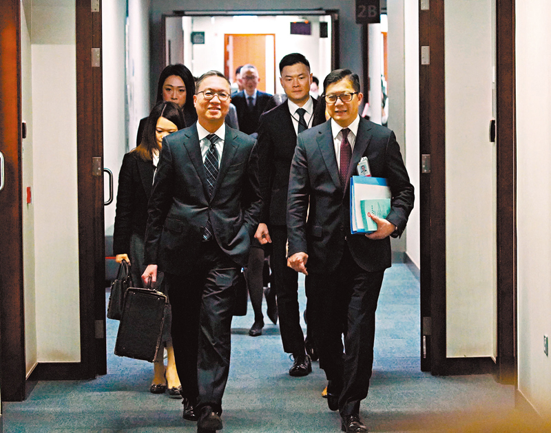 ◆律政司司長林定國（左）和保安局局長鄧炳強（右）昨日滿面笑容步入立法會議事廳。 香港文匯報記者曾興偉  攝