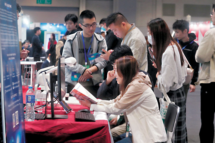 ◆求職者到各參展企業攤位仔細瀏覽招聘職位的相關資訊。香港文匯報記者郭木又 攝