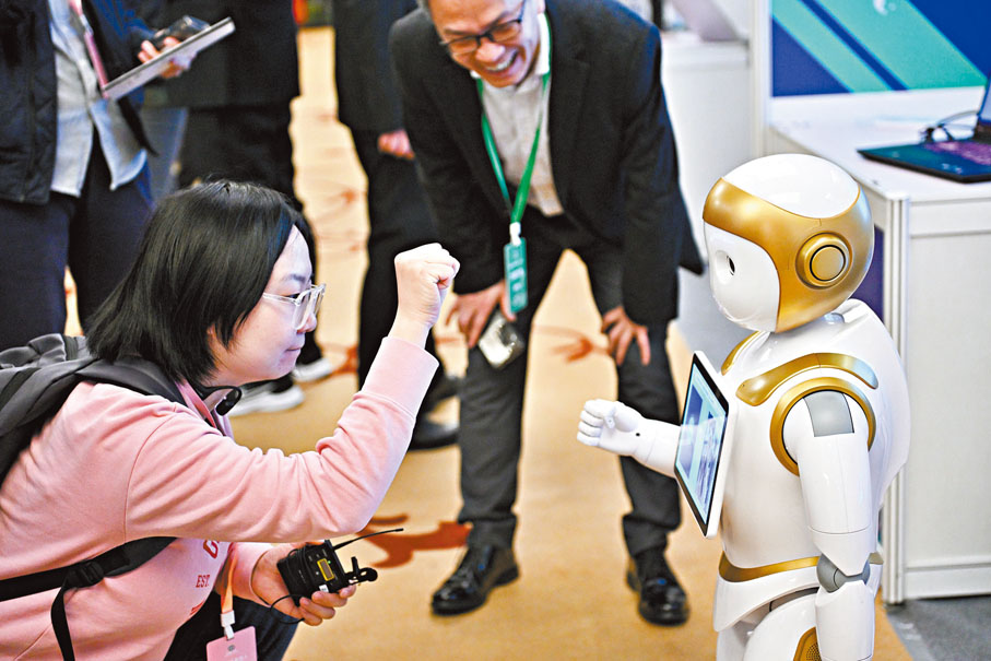 ◆參觀者與一款陪護型人形機器人互動。   中新社