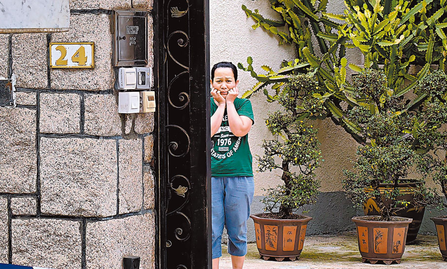 ◆女傭目送死者遺體被運走時神情哀傷。