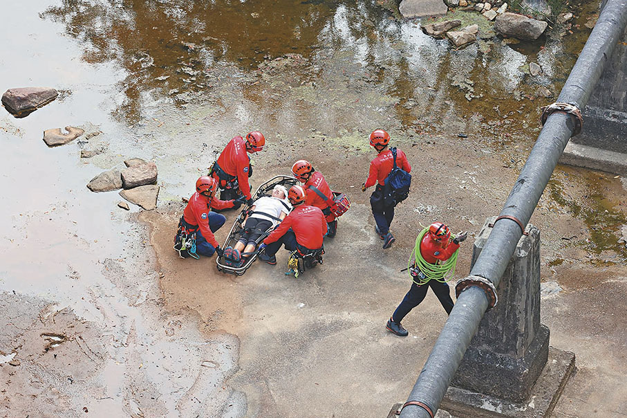 ◆民安隊游繩到水壩底拯救一名昏迷女子。 香港文匯報記者劉友光 攝