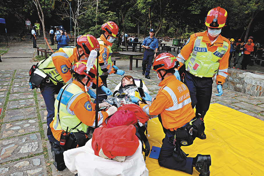 ◆救護人員正為一名準備送院傷者作檢查。 香港文匯報 記者 劉友光 攝