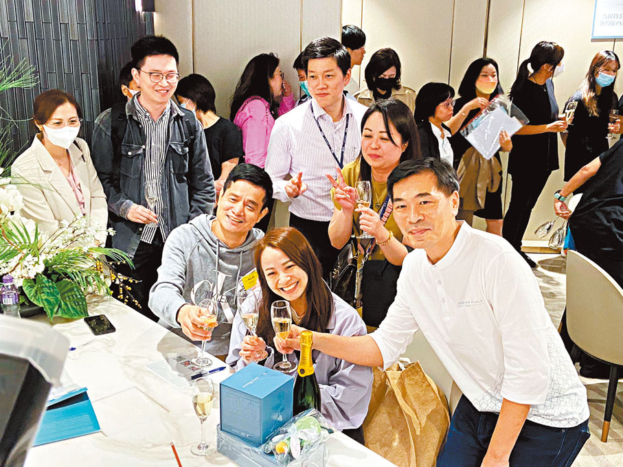 ◆黃先生（左）表示，第一輪抽到但排不到，今次終買入1伙兩房梗廚單位作自住，覺得價錢可以接受，他等「撤辣」後才買樓，相信樓市差不多見底，料會向上。記者梁悅琴 攝