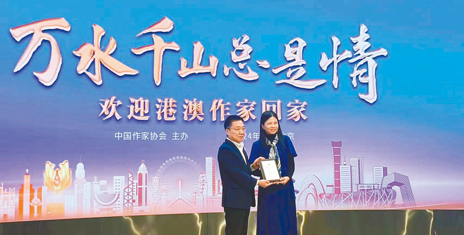 ◆胡邦勝（左）向香港作家代表團副團長羅光萍頒發紀念牌。
