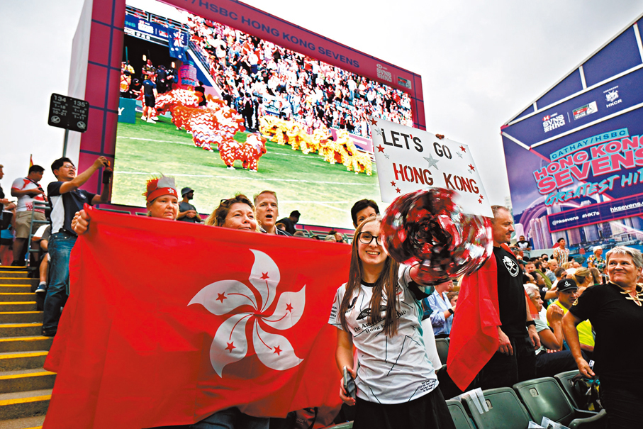 ◆外籍球迷揮舞區旗為香港打氣。 中新社