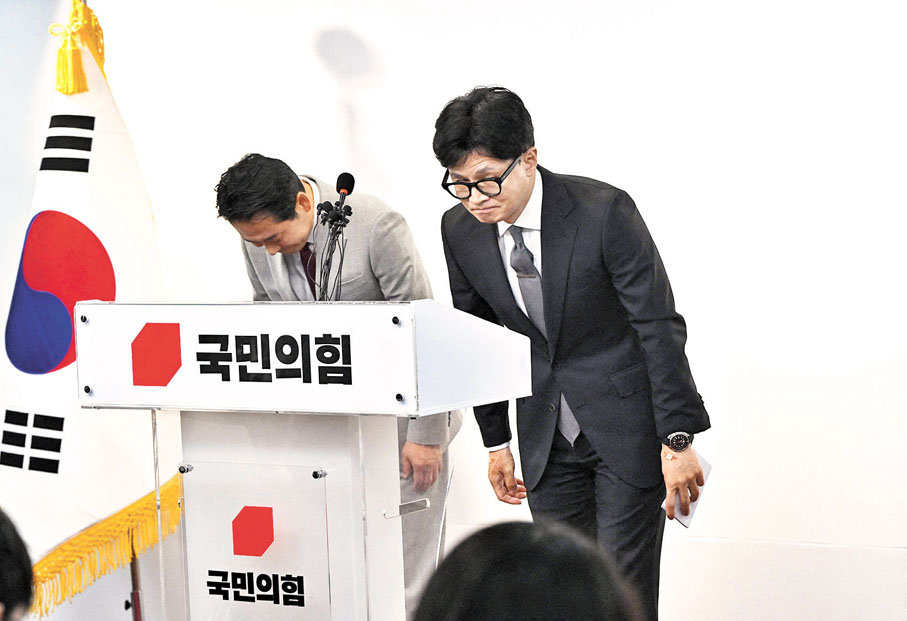 ◆執政黨國民力量黨領導人韓東勳(右)在記者會上道歉。 法新社