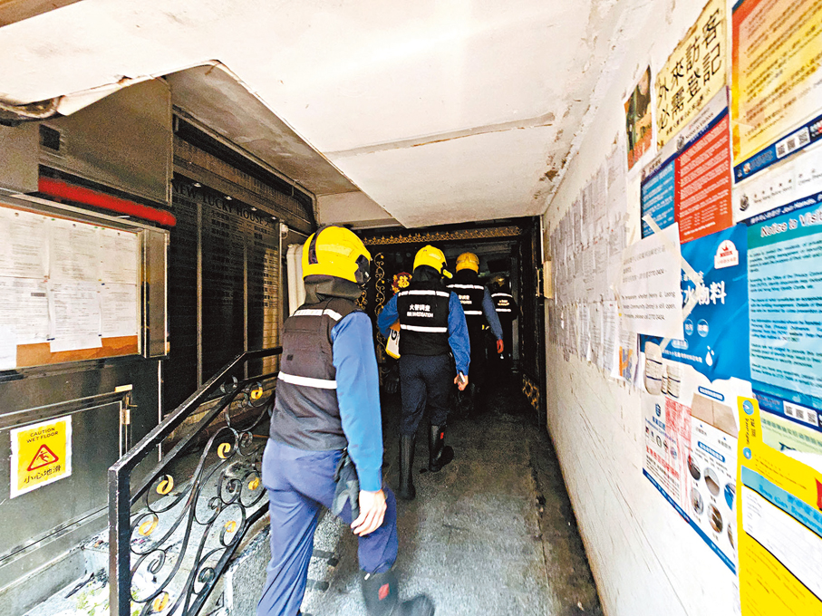 ◆消防員昨日再到華豐大廈調查火警原因。 香港文匯報記者鄺福強 攝