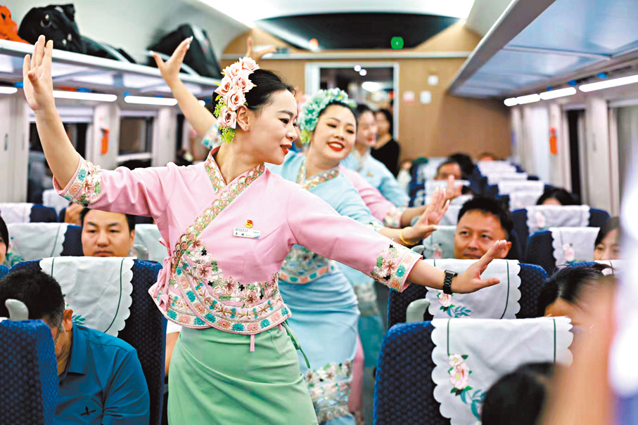 ◆13日，工作人員在中國西雙版納至老撾琅勃拉邦首發列車上表演。香港文匯報雲南傳真