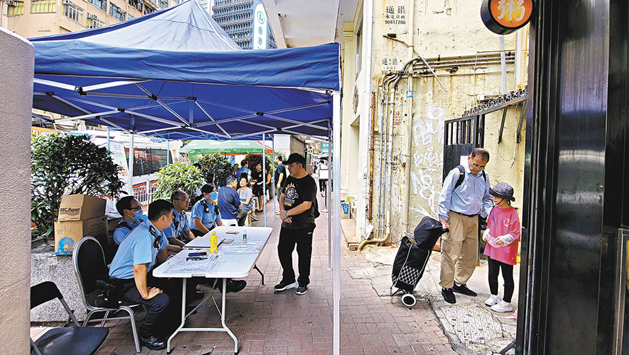 ◆警員負責登記上樓居民資料。 香港文匯報記者鄧偉明 攝