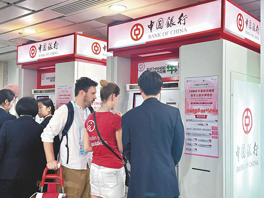 ◆中國銀行廣交會支行員工在廣交會場館內指引境外採購商辦理自助兌換。 新華社