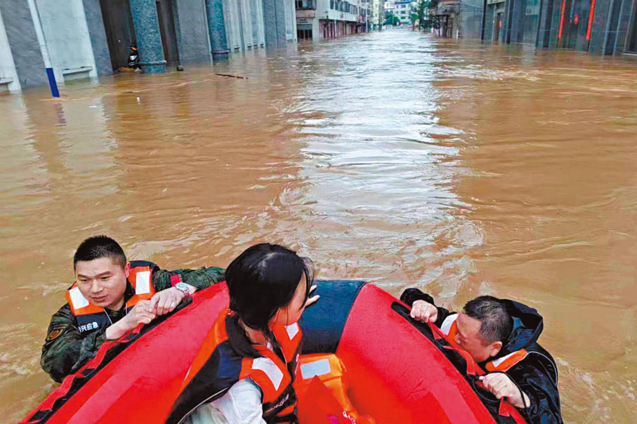 ◆韶關市始興縣的應急救援人員在轉移被困民眾。 中新社