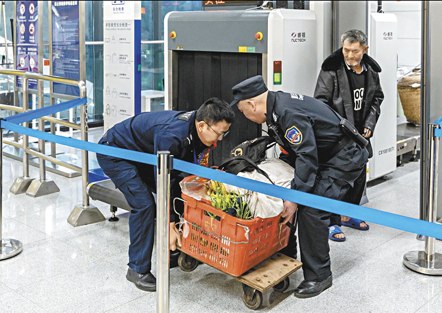◆地鐵工作人員幫助菜農過安檢。 香港文匯報重慶傳真