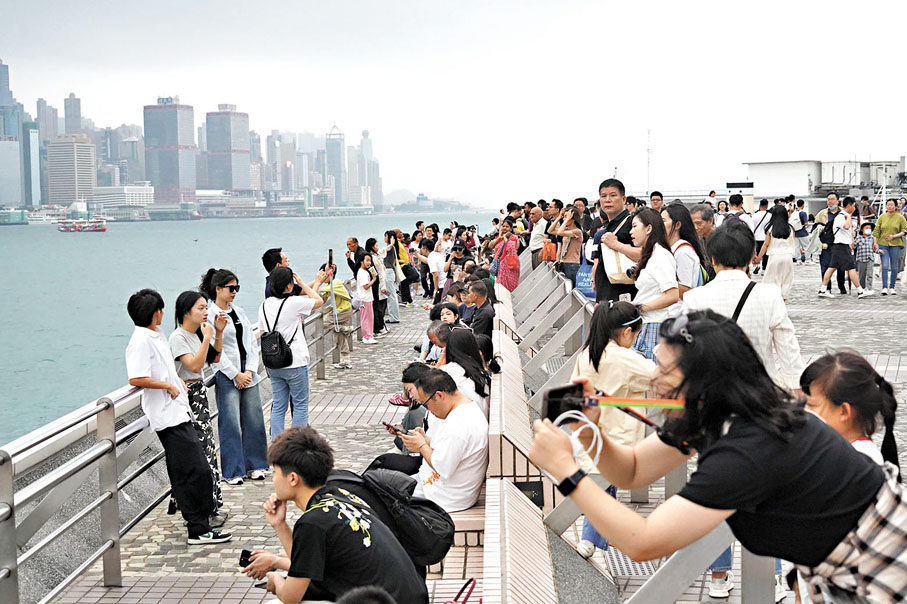 ◆遊客認為，坐在維港邊吹海風、看美景，實是一大享受。香港文匯報記者曾興偉 攝